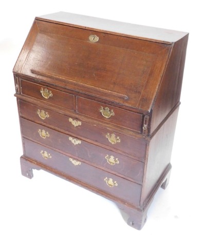 An 18thC oak bureau, the fall enclosing a fitted interior above two short and three long drawers, each with brass escutcheons and drop handles on bracket feet, 107cm high, 91cm wide.