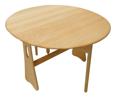 An Ercol light elm drop leaf table, the oval top with a shaped edge on pierced end supports, 107cm wide.