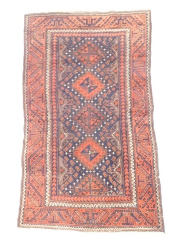 A Turkish rug, with four lozenge shaped medallions, on a navy ground with one wide border, 147cm x 85cm.