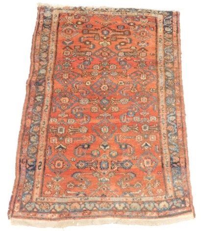 A Persian rug, with an all over geometric design on a red ground with three narrow borders, 118cm x 80cm.