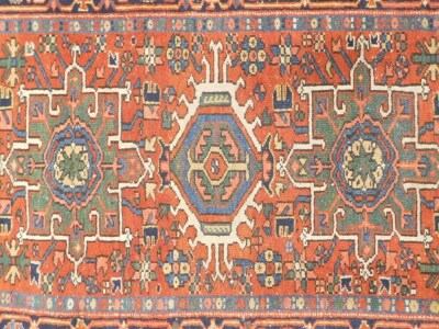 A Karaja rug, with three geometric medallions in blue, beige and green, on a red ground with one wide border, 136cm x 105cm. - 2