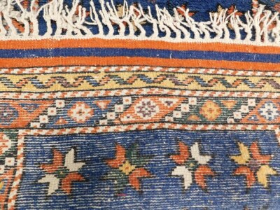 A small Persian rug or mat, with a star design, on a blue ground with multiple borders, 75cm x 59cm. - 3