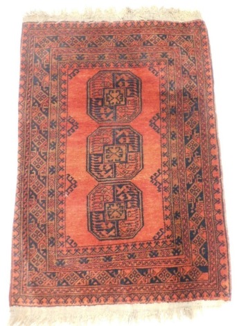 An Afghan Kayam rug, with a design of medallions on a deep orange ground with multiple borders, 142cm x 100cm.