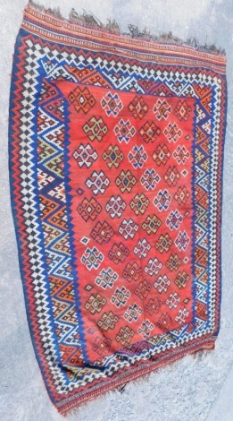 A Kilim carpet, with a geometric design in orange, red, blue and yellow, with one wide border, various narrow borders, 263cm x 171cm.