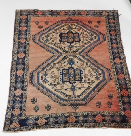 A Persian rug, with a central pole medallion in blue, beige and red, within one wide and two narrow borders, 185cm x 142cm.