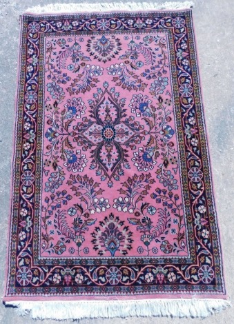 A Persian type rug, with a central medallion surrounded by flowerheads, scrolls, etc., one wide, two narrow borders, 180cm x 118cm.