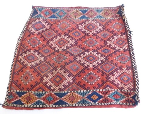 A Persian flat weave Soumak camel bag or Juval, with a design of medallions on a red ground with one wide border, 84cm x 90cm.