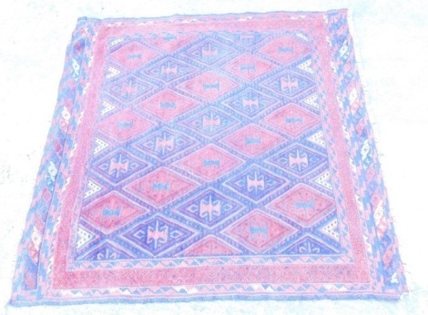 A small Persian rug, with a design of blue and red medallions, with multiple borders, 117cm x 115cm.