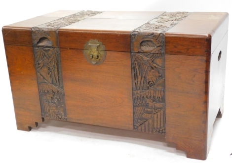 An Eastern camphor wood chest, with carved bands of exotic birds, flowering branches, etc., enclosing a sliding tray, on bracket feet, 100cm wide.