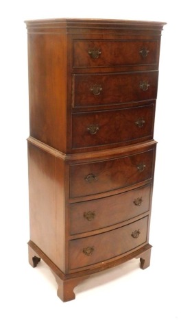 A bow fronted walnut chest on chest, the chest with a moulded cornice above three long drawers, the base with a further three drawers, on bracket feet, 131cm high, 55cm wide.