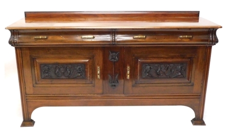 An early 20thC walnut sideboard, with two cushion frieze drawers above a pair of heavily carved panelled cupboards, centred by a stylised lotus flower, on block feet, 105cm high, 85cm wide, 55cm deep.