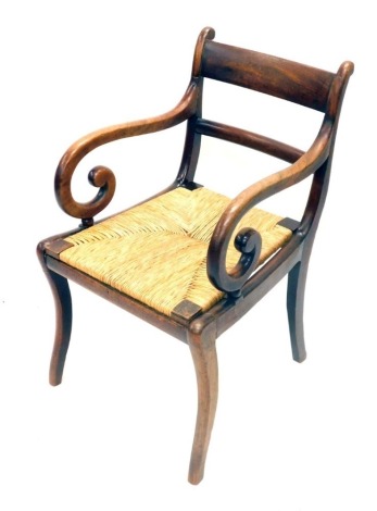 A 19thC mahogany open armchair, with a bar back, rush seat on sabre legs.