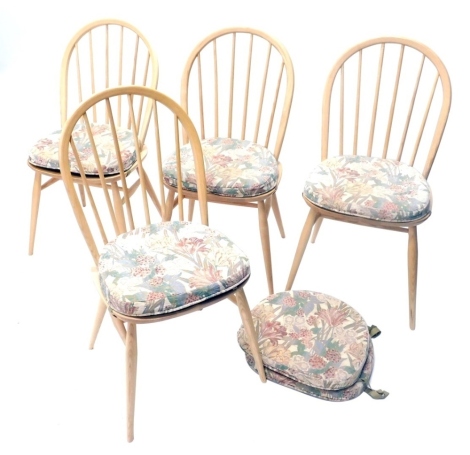 A set of four Ercol beech and light elm stick back dining chair, each with a hoop back, solid seat on turned legs.