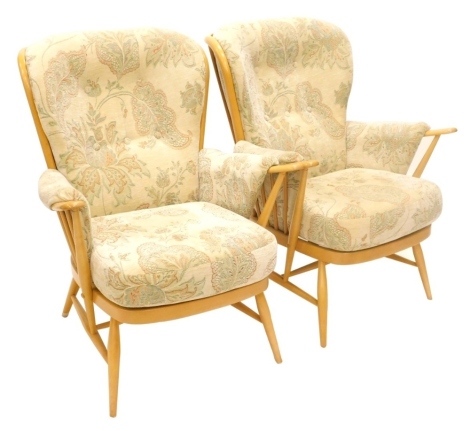 A pair of Ercol light beech spindle back armchairs, with padded backs, arm rests and seats, design no. 914. The upholstery in this lot does not comply with the 1988 (Fire & Fire Furnishing) Regulations, unless sold to a known exporter or upholsterer it wi