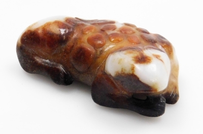 A Chinese white and brown hard stone carving, modelled in the form of a recumbent reptilian creature, 7cm long.