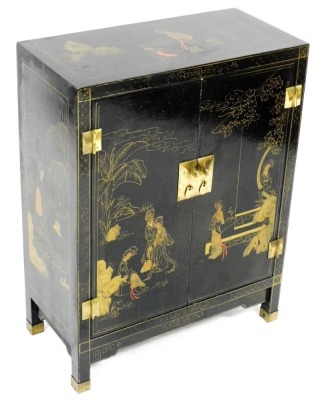 A Chinese black lacquer two door cabinet, decorated with figures, flowering branches, etc., with brass hinges, on brass capped feet, 66cm high, 59cm wide, 28cm deep.