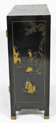 A Chinese black lacquer two door cabinet, decorated with figures, flowering branches, etc., with brass hinges, on brass capped feet, 66cm high, 59cm wide, 28cm deep. - 4