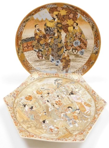 A Japanese earthenware hexagonal shaped plaque, decorated with numerous figures in a village scene, unmarked, 36cm wide, and a Japanese Meiji period earthenware plaque, with similar decoration (AF), 32cm diameter.