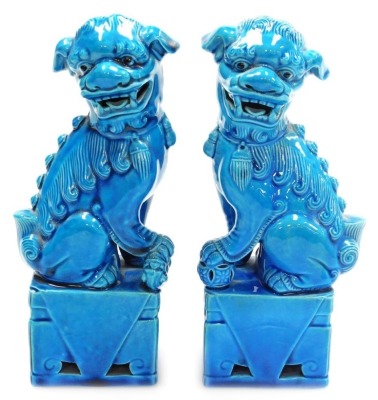 A pair of 20thC Chinese porcelain dogs of fo, each glazed in blue, 20cm high, stamped Made in China to underside.