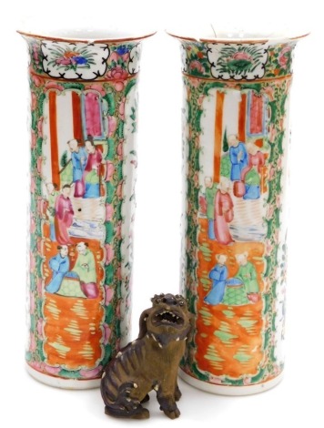 A pair of Cantonese famille rose porcelain vases, with flared rims, decorated with reserves of figures, flowers, birds, etc., 30cm high (AF), and a 19thC pottery figure of a dog of fo, 11cm high. (AF)