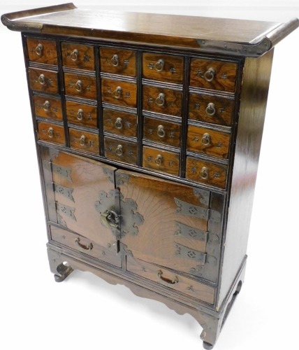 A Chinese elm spice or apothecary cabinet, with an arrangement of twenty drawers, above a pair of cupboard doors and two further drawers, raised on bracket feet, 76.5cm high, 60cm wide, 25cm deep.