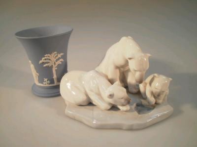 A Lladro figure group of three polar bears looking into an ice pool