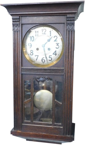 A mid 20thC oak cased wall clock, the 17cm diameter dial with Arabic numerals, flanked by acanthus capped columns and fronted by an astragal glazed door revealing pendulum, eight day movement, 62cm high.