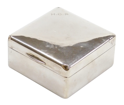 A George V silver cigarette box, of plain square form, engraved H C P, the hinged lid enclosing a treen interior, London 1922, 9cm wide.