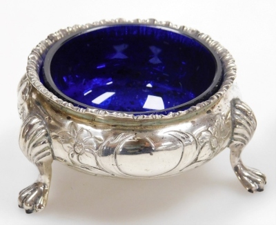 Five Victorian silver circular salts, embossed with flowers and leaves and monogram engraved cartouches, each raised on three hoof feet, one lacking blue glass liner, dates for London 1857 and 1867, weighable silver 10.52oz. - 4