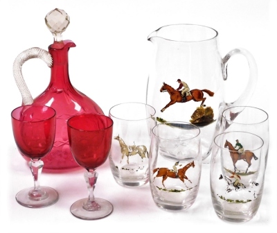 An early 20thC cut glass water set, decorated in enamels with steeplechase figures on horseback, together with a cranberry glass claret jug and stopper, and two cranberry wine glasses.