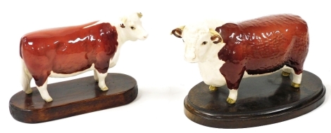 A Beswick Champion Of Champions Bull, printed marks, together with a Champion Of Champions Cow, both raised on oval wooden bases. (2, AF)