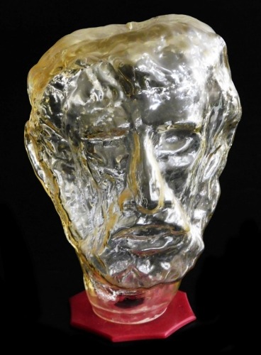 A modernist art glass sculpture of a man's bust, raised on a red Perspex base, 32cm high.