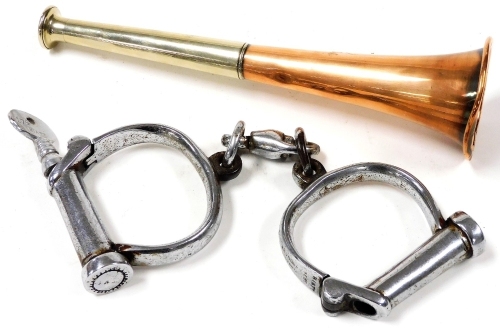 A pair of Hiatt handcuffs, stamped 174, together with a copper and silver plated hunting horn, 22.5cm wide. (2)