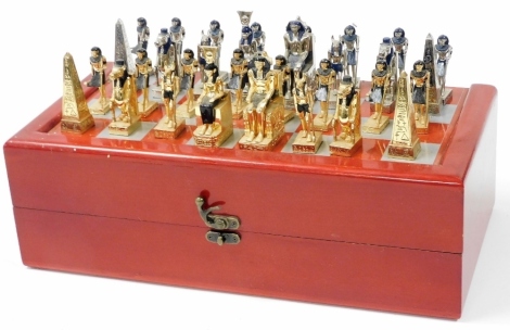 A red stained beech games box, with a chessboard top, together with an Ancient Egyptian style metal chess set.