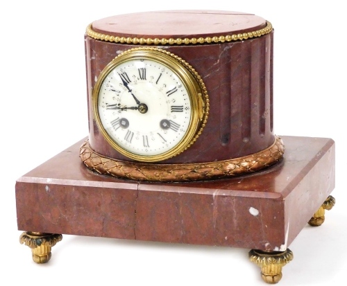 A late 19thC French porphyry marble cased mantel clock, circular enamel dial bearing Roman numerals, eight day movement by L Marti & Cie, with bell strike, the case of fluted column form, raised on a square plinth, on embossed brass feet, bell, pendulum,