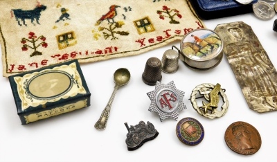 Various bygones and collectables, commemorative crowns, an Earl Mountbatten of Burma token, a 19thC alphabetic sampler (Jane ?), unframed, 27cm x 21cm, corkscrews, pipe, various badges, thimbles, plated napkin ring, etc. (1 tray) - 5