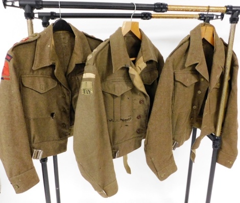 Three World War II British Army battle dress serge shirts, one bearing applied badges for the Royal Artillery, another for Home Guards, and a further unmarked. (3)