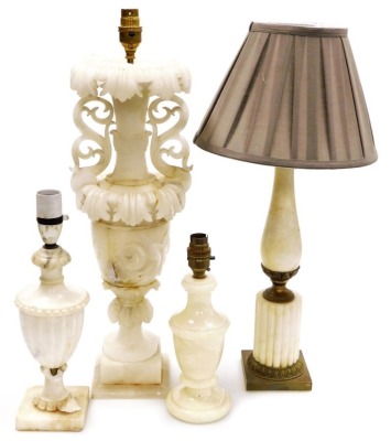 An Italian alabaster table lamp, of twin handled baluster form, carved with leaves and roses, 35cm high, two further alabaster table lamps and an onyx table lamp. (4)