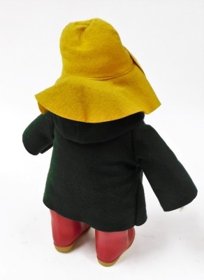 A Paddington Bear, wearing a yellow felt hat, green felt duffel coat, and red Wellington boots, 50cm high. - 2