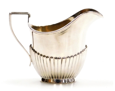 An Edward VII silver helmet shaped cream jug, of semi fluted form, Jones and Crompton, Birmingham 1909, 2.14oz, 9cm high.