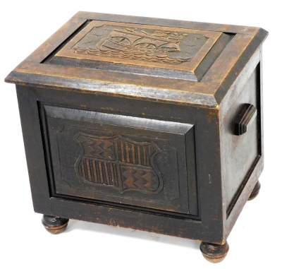 An early 20thC oak coal box, carved to the lid with a galleon, coat of arms to the front, raised on turned feet, 41cm high, 43cm wide, 33cm deep.