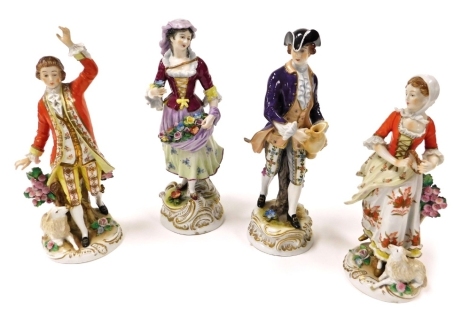 A pair of 20thC Sitzendorf porcelain figures of a shepherd and shepherdess, in 18thC costume, raised on a circular rococo base, 26cm high, and two further figures, modelled as a flower seller, 27cm high, and a gallant holding a jug, 26cm high. (4)