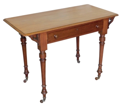 A 20thC mahogany side table, with a single frieze drawer and pierced scroll supports, raised on turned and reeded legs terminating on castors, 70cm high, 98cm wide, 50cm deep.