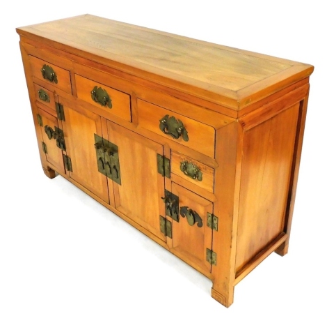 A Chinese elm altar cabinet or sideboard, with three drawers above two cupboards, flanked by a pair of small shallow drawers, above two narrow cabinets, with shaped brass plates, raised on carved bracket feet, 87cm high, 140cm wide, 44cm deep.