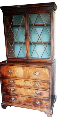 A George III mahogany secretaire bookcase, the outswept pediment with Gothic moulding over four adjustable shelves, above a fall flap opening to reveal a baize interior, six recesses over two long drawers, flanked by six further drawers and two recesses, 