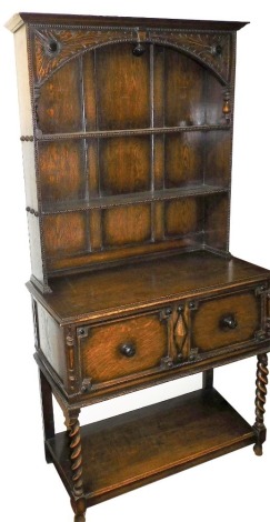 An early 20thC oak dresser, the outswept pediment over a two shelf plate rack over two deep drawers, raised on spiral twist legs, united by an under tier, on ball feet, 192cm high, 99cm wide, 44.5cm deep.