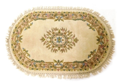 A Jalina Indian wool rug, of oval form, on a cream ground with central floral lozenge within a floral border, 122cm x 76cm.