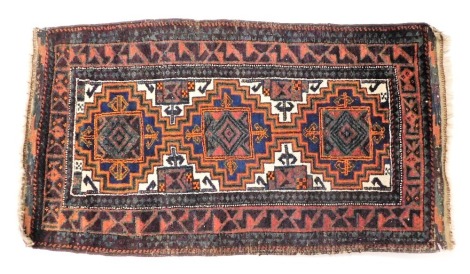 A Turkish rug, decorated with three central lozenges, with multiple borders, 54cm x 92cm.