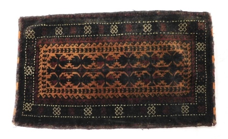 An Afghan Baluchi Pushti, decorated with two rows of guls within multiple borders, 47cm x 77cm.