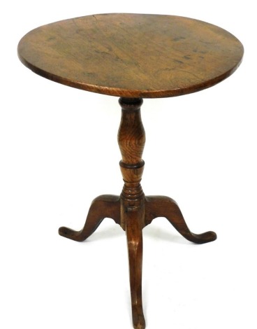 A Georgian elm tilt top occasional table, raised on a baluster turned column over three cabriole legs, 74cm high, 62cm diameter. 